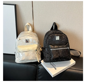 Detailed view of silver and black polka dot mini backpacks with pearlescent leather finish