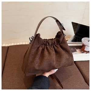 Détail du sac nuage en daim marron café avec texture plissée et poignée en cuir