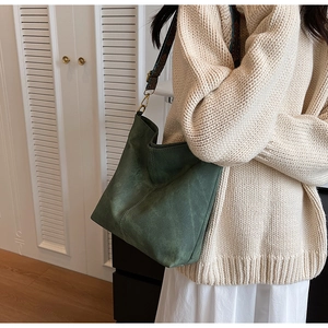 Detail of dark green suede tote with vintage geometric jacquard wide shoulder strap