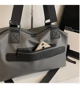 Close-up of front zipper pocket on grey travel bag showing phone storage and nylon texture