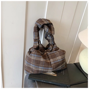 Detail of retro plaid tote bag with twisted handle and wool-like textured fabric