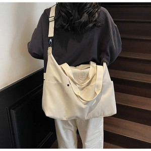 Rear view of a person carrying a large canvas sports tote bag on stairs in a lifestyle setting