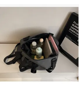 Spacious interior of dark grey gym bag showing storage for water bottle and tablet