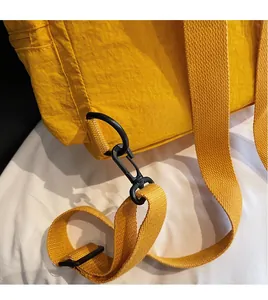 Close-up of durable black swivel hook and yellow woven strap on a nylon backpack