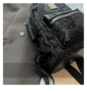 Detailed view of black rhinestone backpack with high-quality metal zippers and leather trim