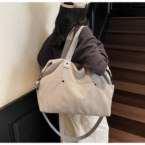 Detail view of a large canvas gym bag featuring multiple pockets and adjustable shoulder strap