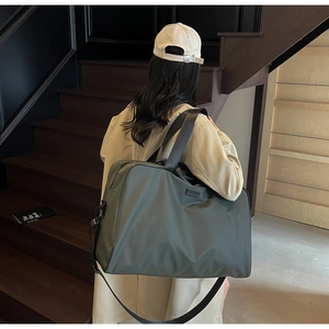 Close-up of olive green waterproof oxford fabric travel bag on wooden stairs