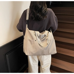 Detail view of large canvas fitness bag with adjustable strap on vintage stairs