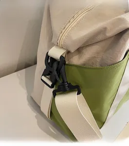 Close-up of durable black shoulder strap hook and fabric on the green travel bag