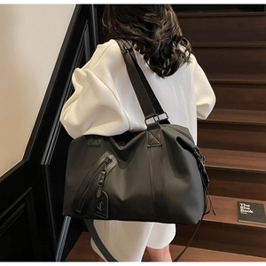 Large capacity black travel bag made of durable nylon shown on a shoulder strap