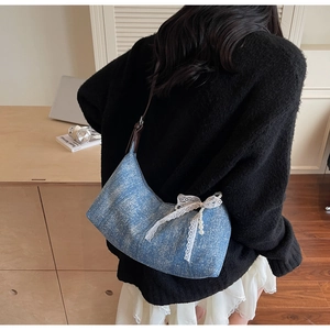 Detail der blauen Hobo-Tasche mit Spitzen-Schleife und Perlenketten-Verzierung