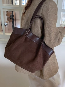 Large dark brown suede tote bag with contrast leather handles shown on a model