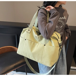 Lime green fitness bag with double handles and adjustable strap shown on model