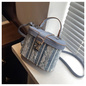 Detail of blue denim and lace bucket bag with leather trim and retro metal buckle