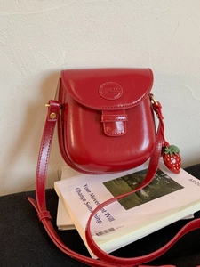 Retro red glossy saddle bag with strawberry charm and adjustable leather shoulder strap