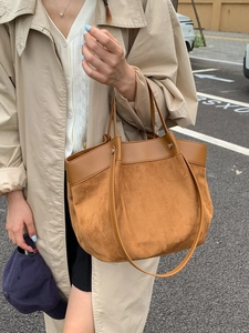 Caramel large tote bag with suede and leather patchwork, shown in a stylish outdoor setting