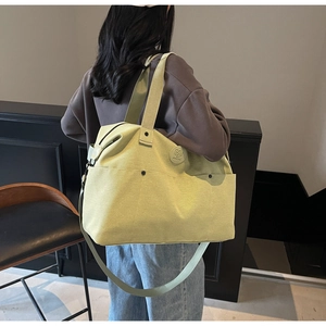 Detail shot of a neon yellow large capacity gym bag with handle and shoulder strap