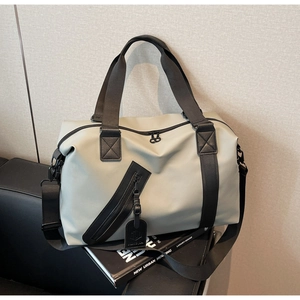 Close-up of light gray travel bag with diagonal front zipper and premium matte fabric