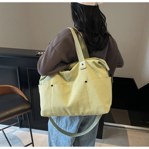 Detail showing lime green canvas duffel bag with shoulder strap and side pockets