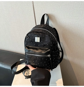 Mini black polka dot backpack with leather zip pocket and silver metal hardware details