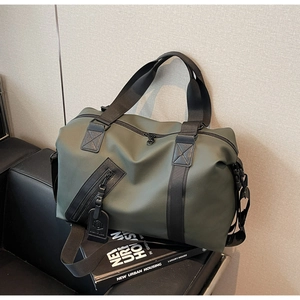 Detail of army green travel bag with reinforced black handles and adjustable shoulder strap