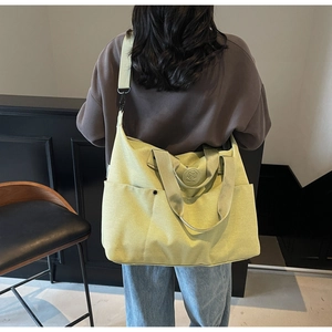 Pale green fitness duffle bag with wide shoulder strap carried by model in casual setting