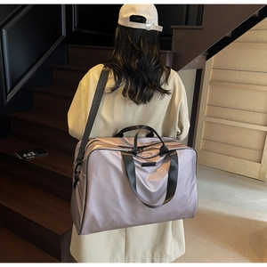 Detail of lavender satin gym bag with black straps on a person for size comparison