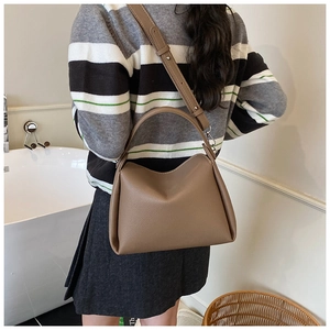 Sac seau en cuir grainé marron porté en bandoulière avec bandoulière réglable et détails argentés