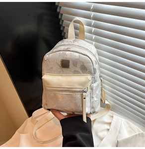 Detail view of mini backpack with cracked silver texture and metallic rivet accents