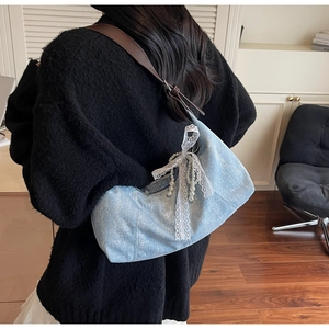 Schultertasche aus blauem Denim mit funkelnden Strasssteinen und weißer Schleife