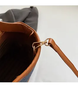 Gros plan du sac seau marron avec ferrures dorées et détails de doublure rayée