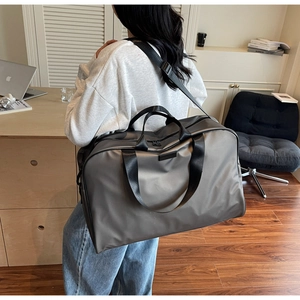 Detail of grey waterproof nylon travel tote bag with black handles and shoulder strap