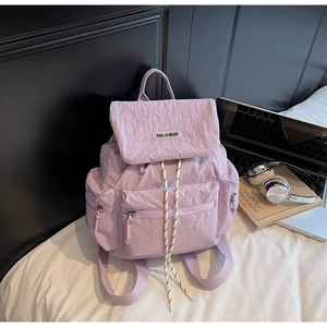 Detail of light purple nylon backpack with drawstring closure and side zipper pockets