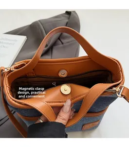 Détail du fermoir magnétique et de la poche zippée du sac seau en denim