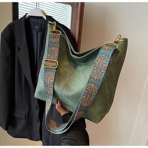 Close-up of retro green tote bag with detailed ethnic style geometric shoulder strap