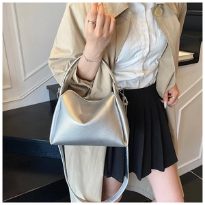 Detail showing high-quality lychee texture and metallic finish on silver crossbody bag