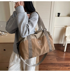 Large travel bag detail showing khaki color combo and reinforced handles and strap