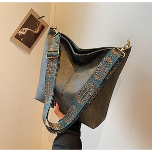 Detail of vintage hobo bag with wide ethnic style colorful woven shoulder strap