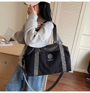 Detailed shoulder view of a large black and grey nylon travel bag for fitness and sports