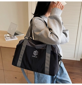 Detail of spacious grey and black travel bag with adjustable strap in office setting