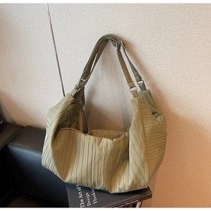 Detail of green pleated hobo bag with textured fabric and adjustable strap