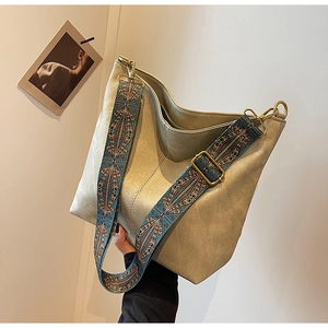 Detail of khaki hobo bucket bag with ethnic embroidery shoulder strap and golden hardware