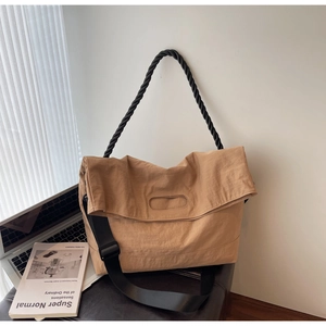 Macro detail of khaki textured nylon crossbody bag with woven handle and wide strap