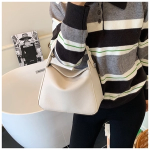 Detail of premium lychee grain cream hobo bag showing wide strap and metallic buckle