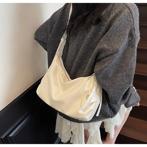 Detail of soft cream hobo bag with adjustable wide strap and smooth matte leather texture