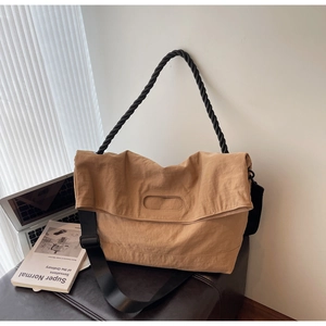 Detail of khaki large messenger bag with wide nylon strap and braided rope handle