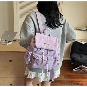 Detailed back view of a lilac nylon backpack featuring a drawstring and flap closure