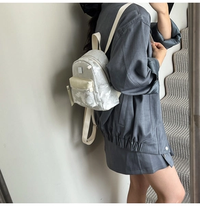Side view of a white mini fashion backpack on a model showing daily carrying style
