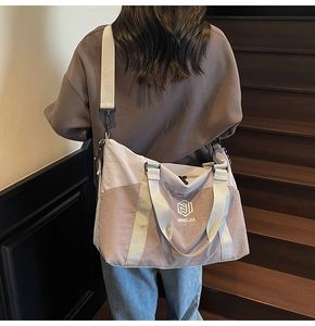 Detail of adjustable wide shoulder strap on a large capacity travel bag in lavender and pink