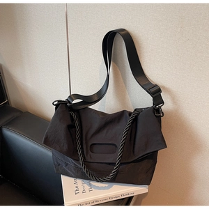 Detail of black nylon crossbody bag with chunky rope handle and wide shoulder strap